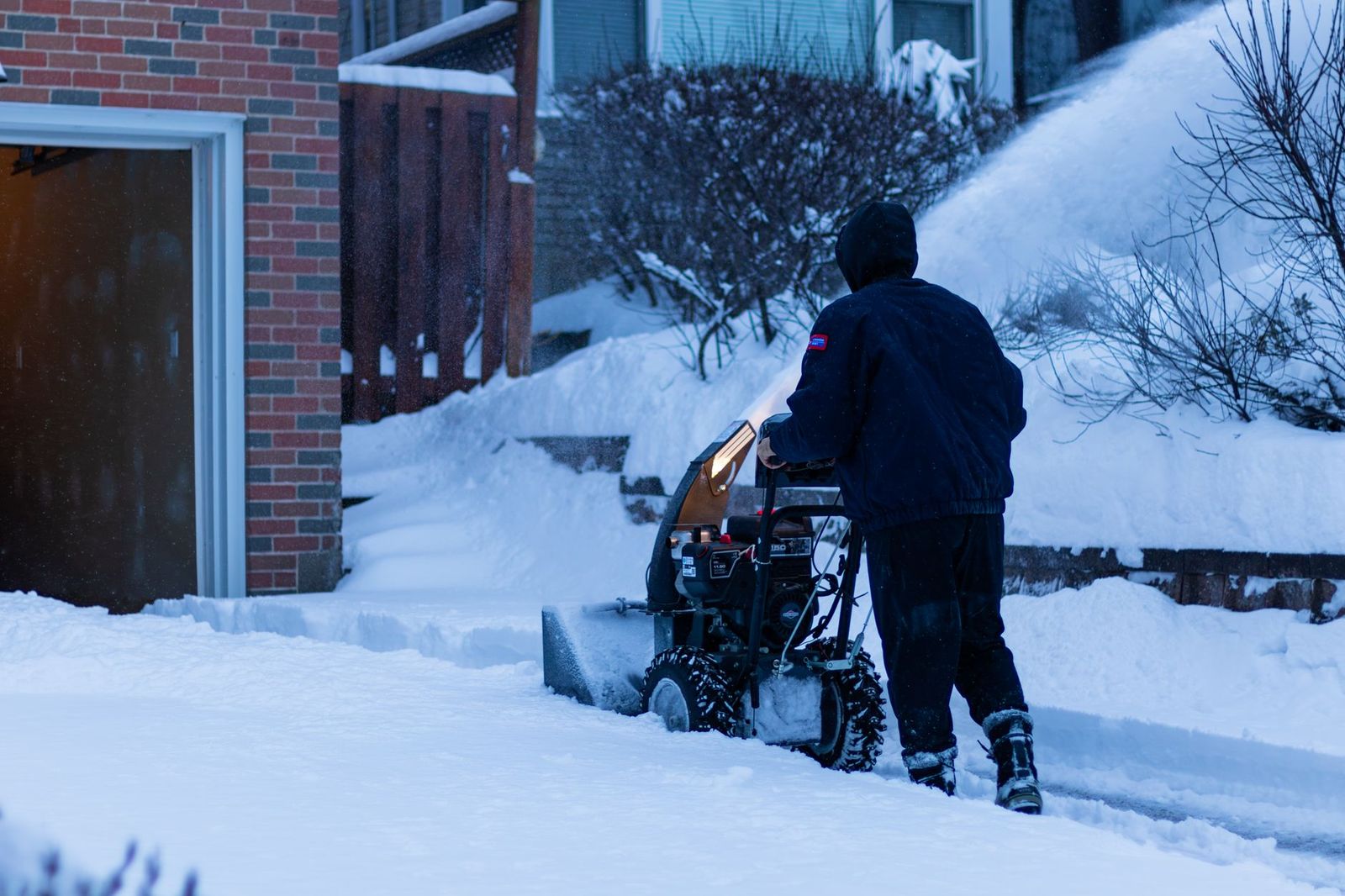Snow plowing service clearing residential driveway in Natick MA